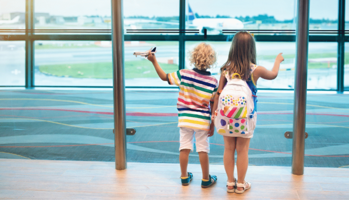 Two children in airport looking at planes