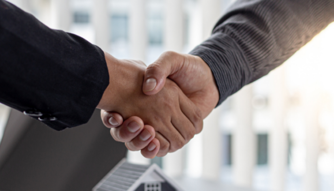 Two businesspeople shaking hands, representing the possible end result of a commercial dispute resolution.