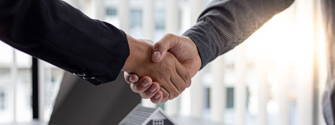 Two businesspeople shaking hands, representing the possible end result of a commercial dispute resolution.